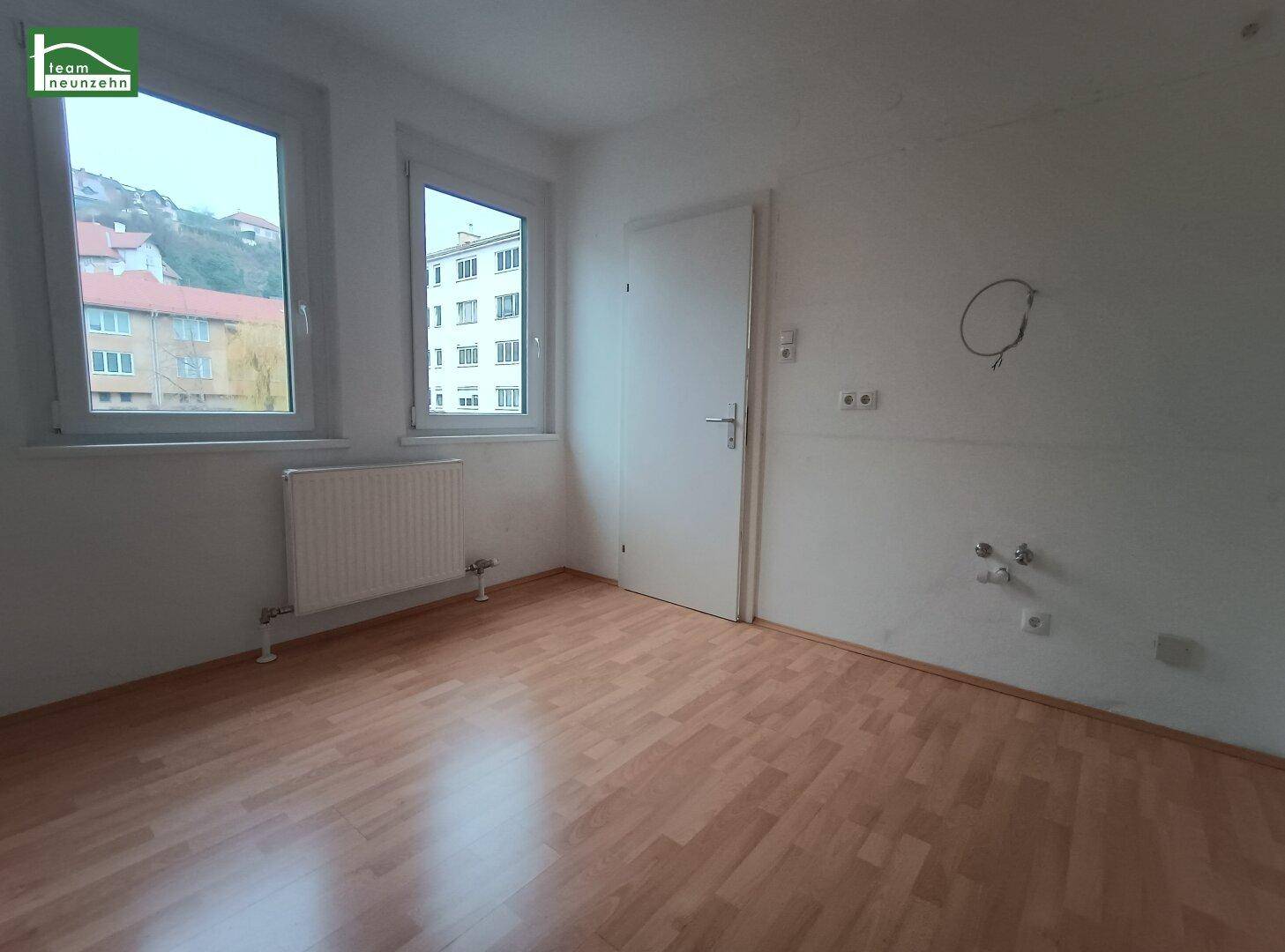 Helles Zimmer mit Anschlüssen für eine Küche und Blick ins Grüne.