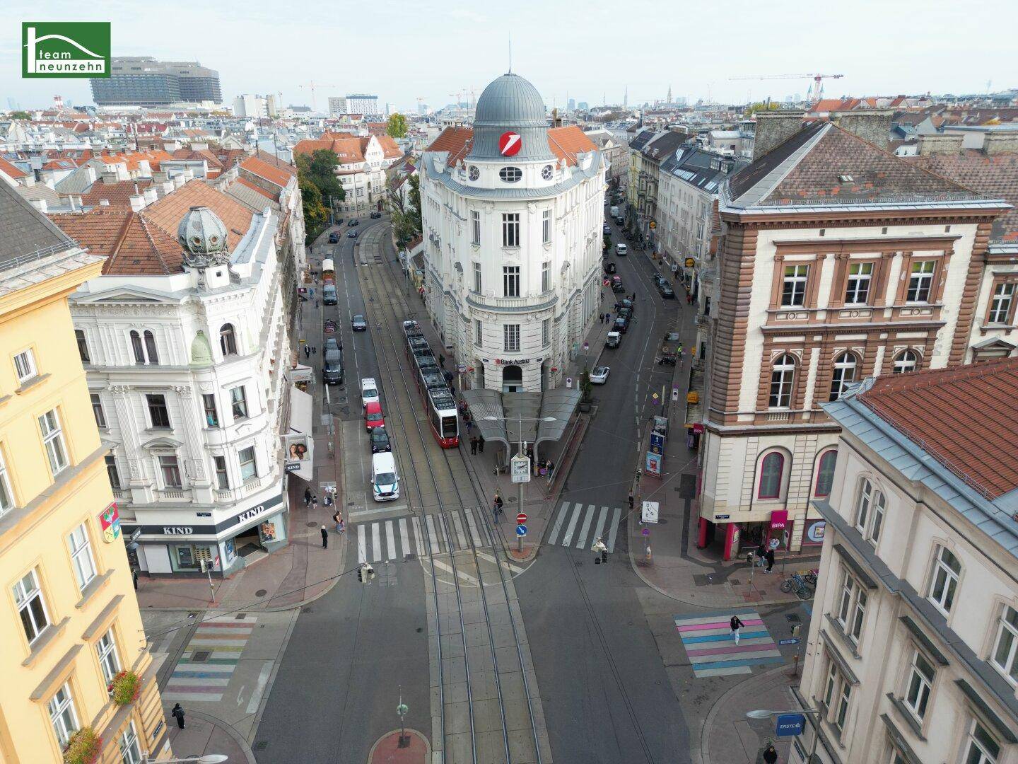 Weitblick über eine städtische Kreuzung mit markanten Altbauten und regem Stadtleben.