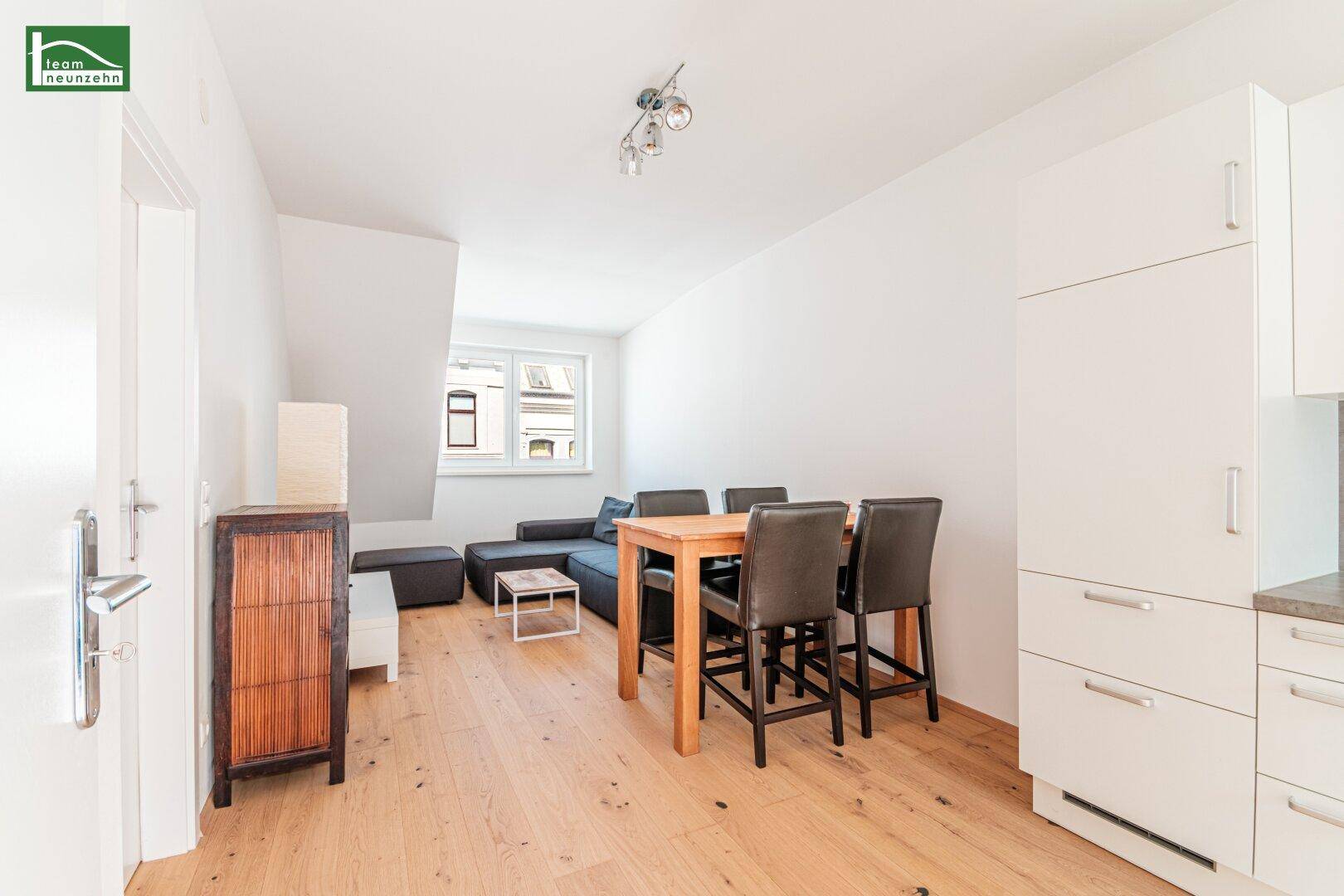 Geräumiger Wohn- und Essbereich mit Holzboden und schlichten Möbeln, ideal für geselliges Beisammensein.