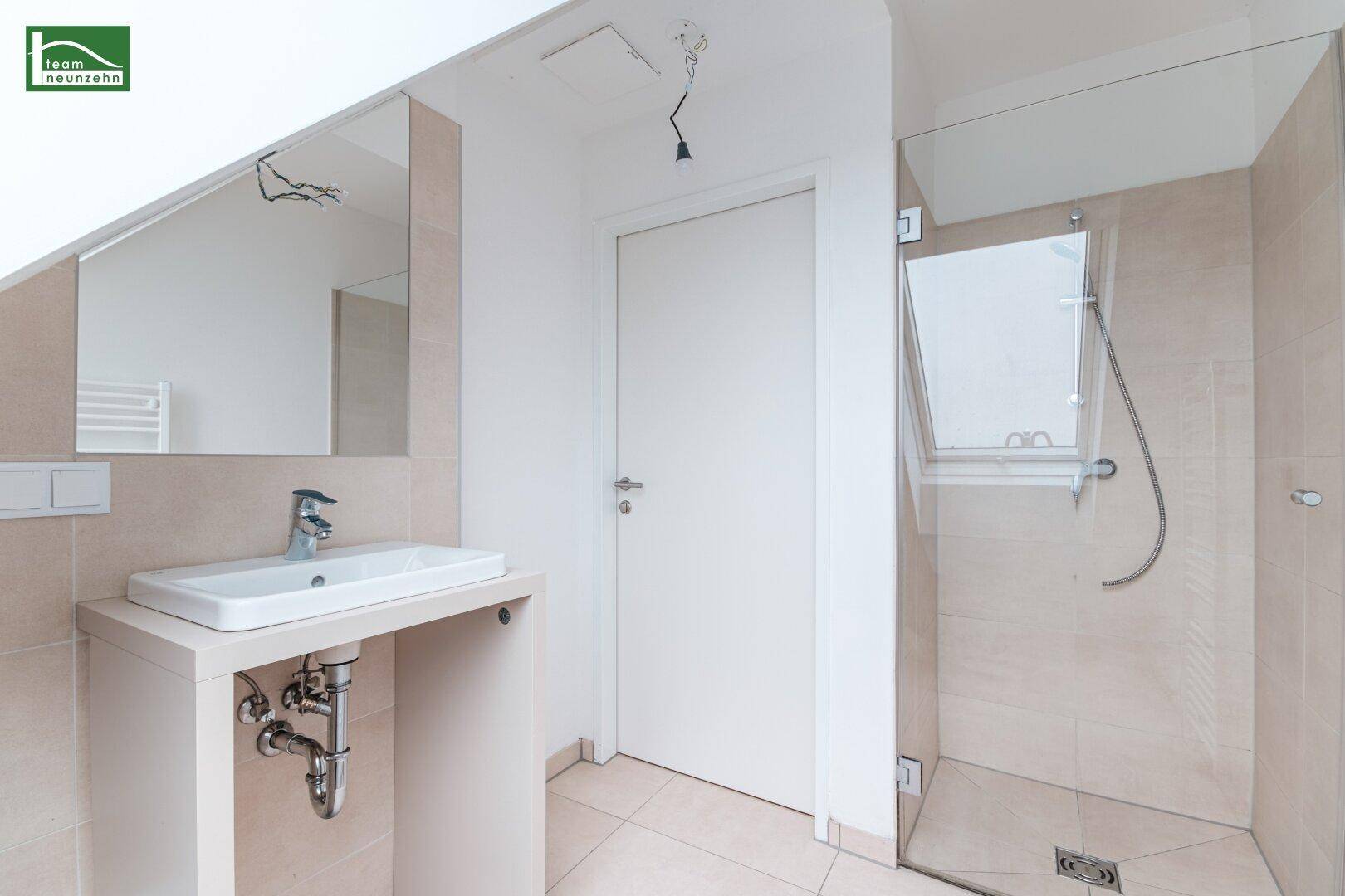 Modernes Badezimmer mit Duschkabine, Waschbecken und großem Spiegel.