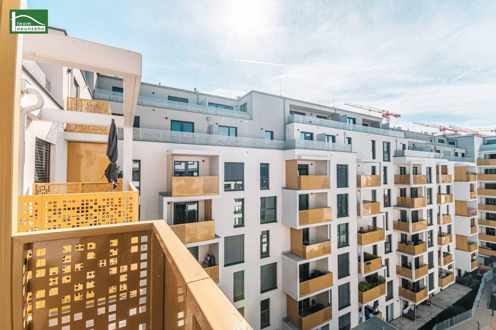 Blick von einem Balkon auf die moderne Fassade des Wohngebäudes mit weiteren Balkonen.