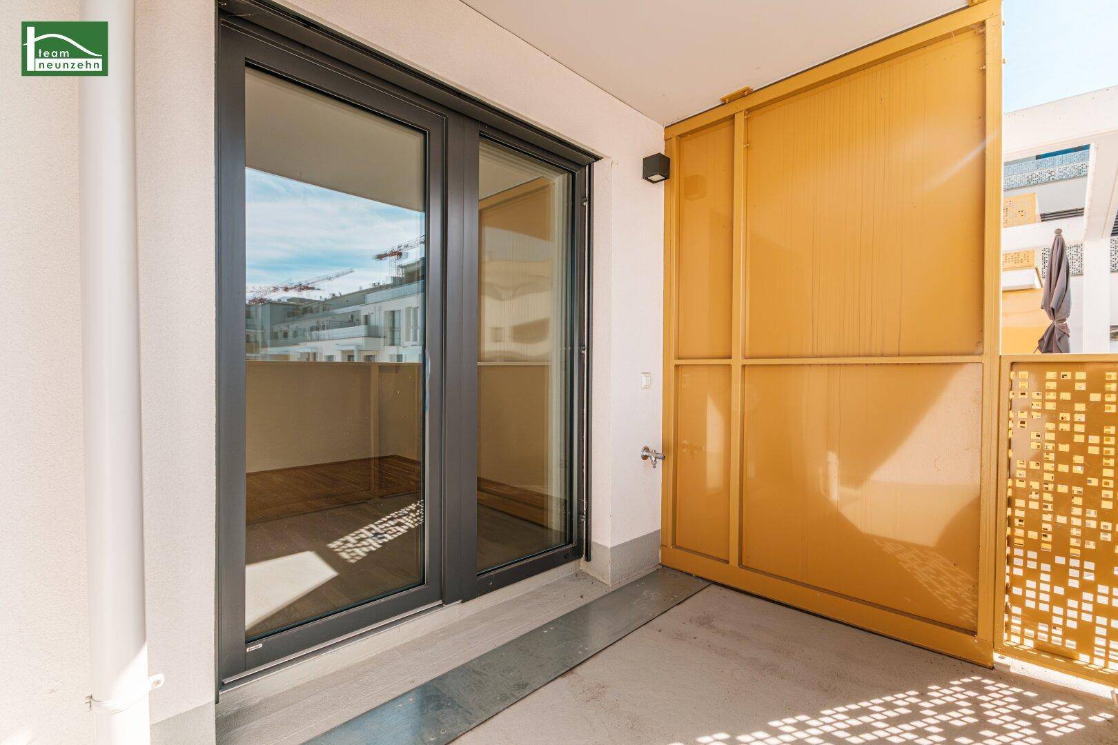 Geräumiger Balkon mit Schiebetüren und dekorativem gelbem Geländer.