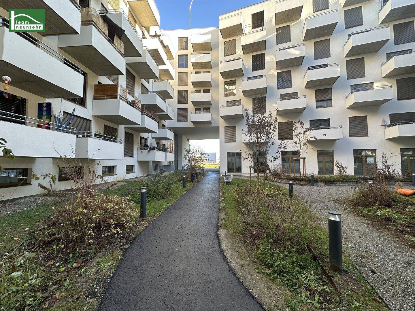 Moderner Wohnkomplex mit begrüntem Innenhof und Wegen.