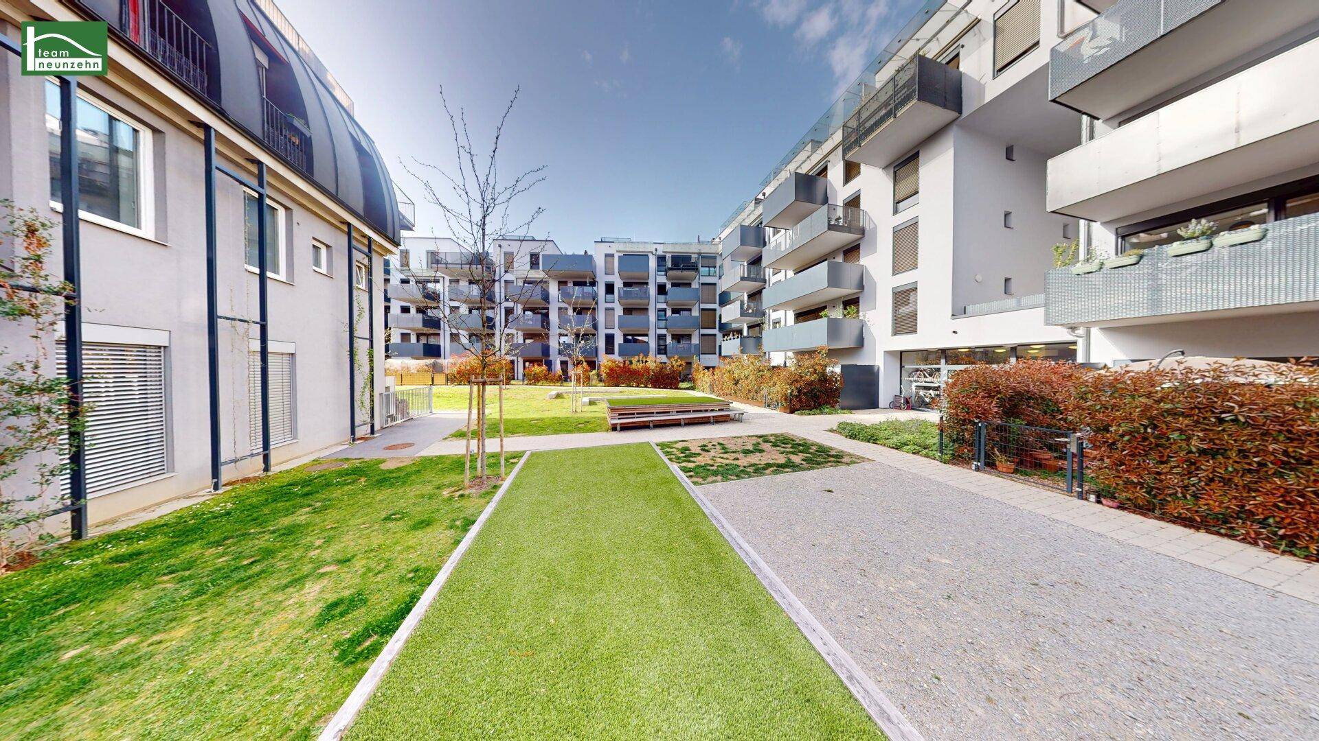 Gepflegter Innenhof mit Grünflächen und modernen Wohngebäuden.