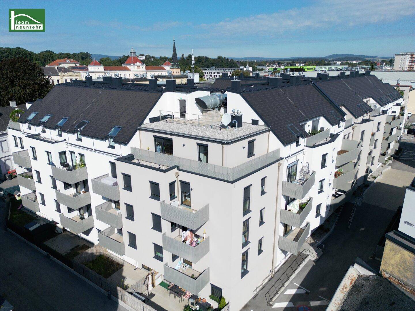 Moderne Wohngebäude-Fassade des Karmeliterhofs mit zahlreichen Balkonen und großen Fenstern.