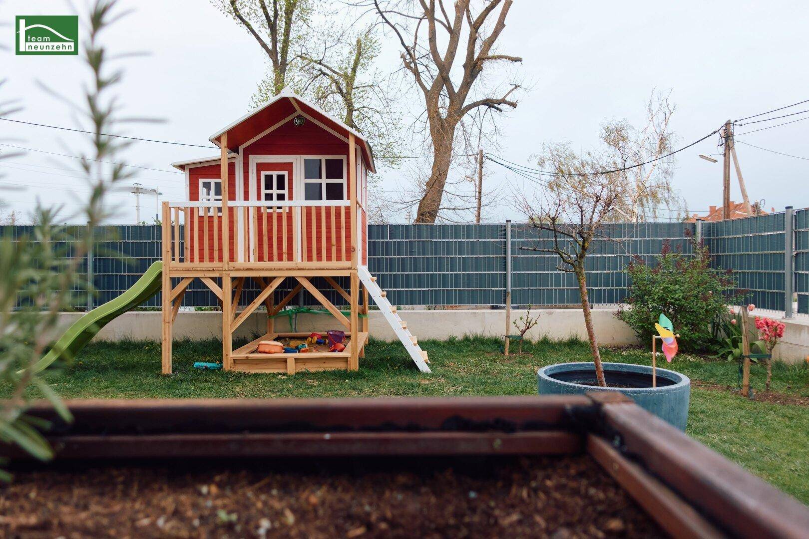 Garten mit Spielhaus, Sandkasten und Hochbeet, ideal für Familien mit Kindern.
