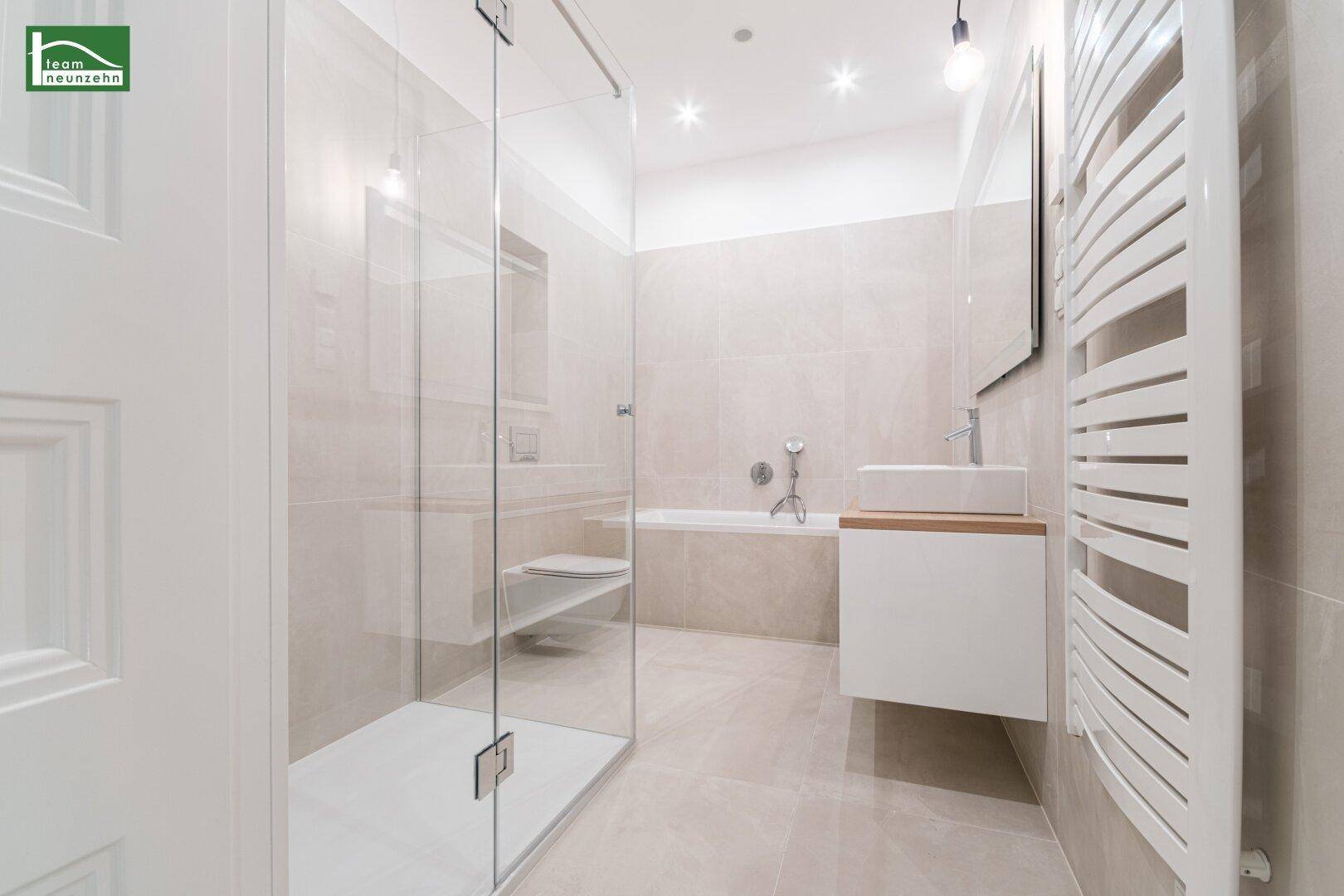 Modernes Badezimmer mit begehbarer Dusche, Badewanne und beheiztem Handtuchhalter.