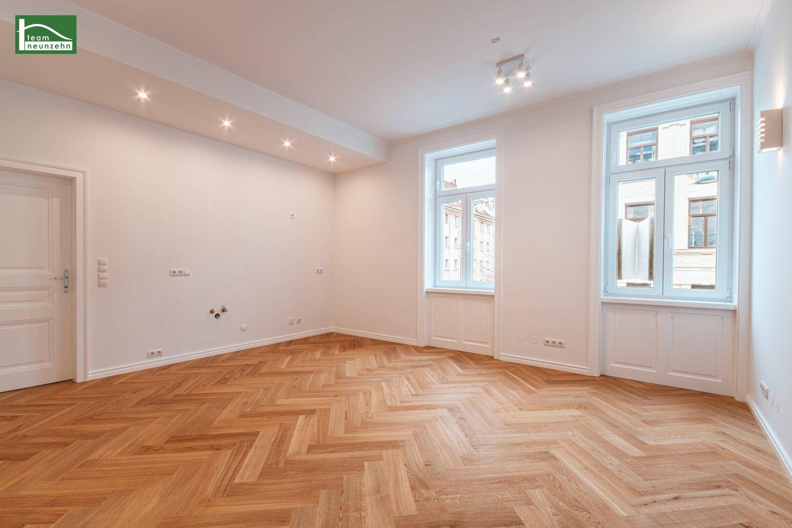 Großes, helles Zimmer mit Fischgrätparkett, Einbaustrahlern und zwei hohen Fenstern, frisch renoviert.