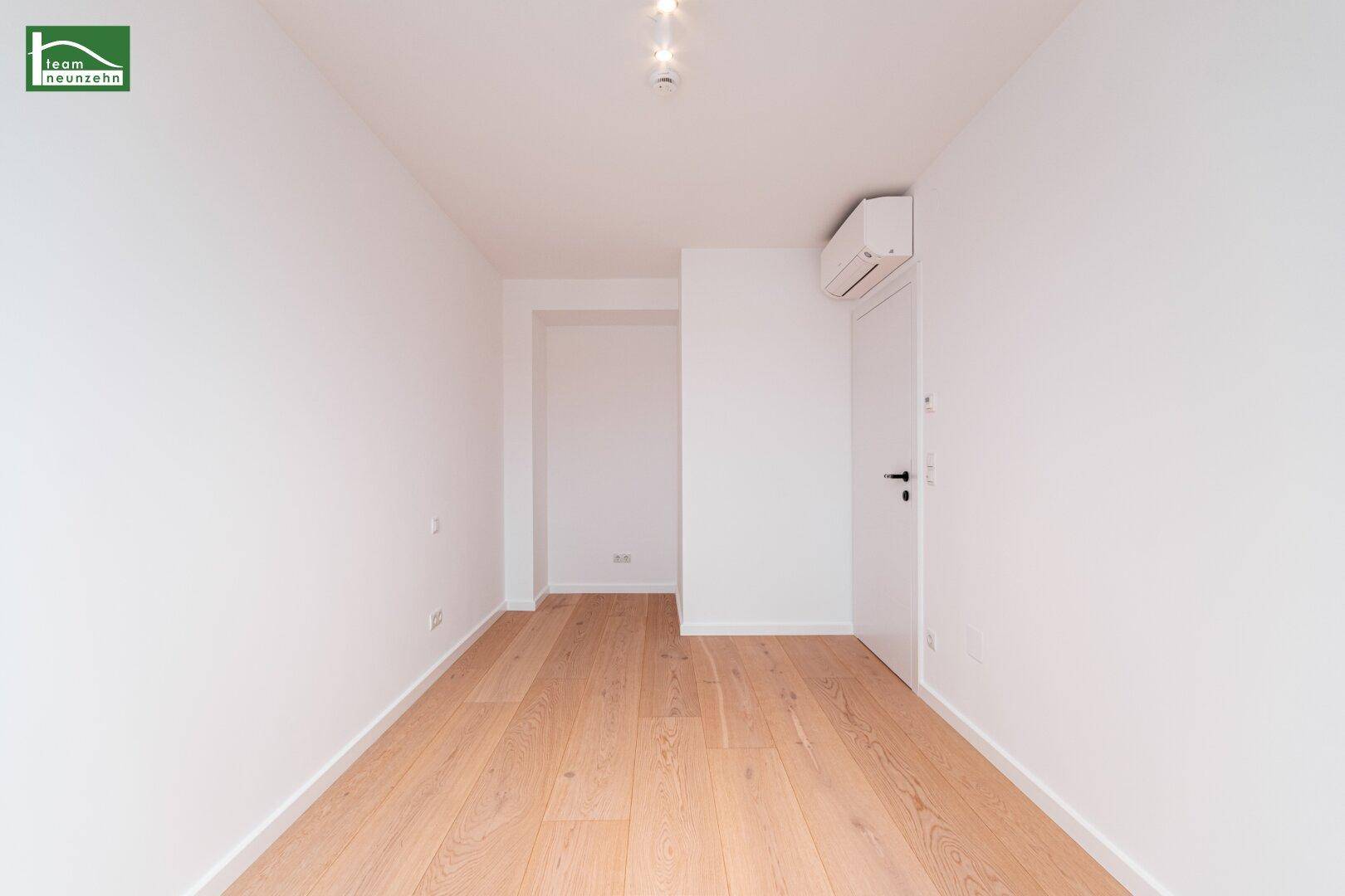 Helles Zimmer mit Holzboden und Klimaanlage, bereit zur individuellen Gestaltung.