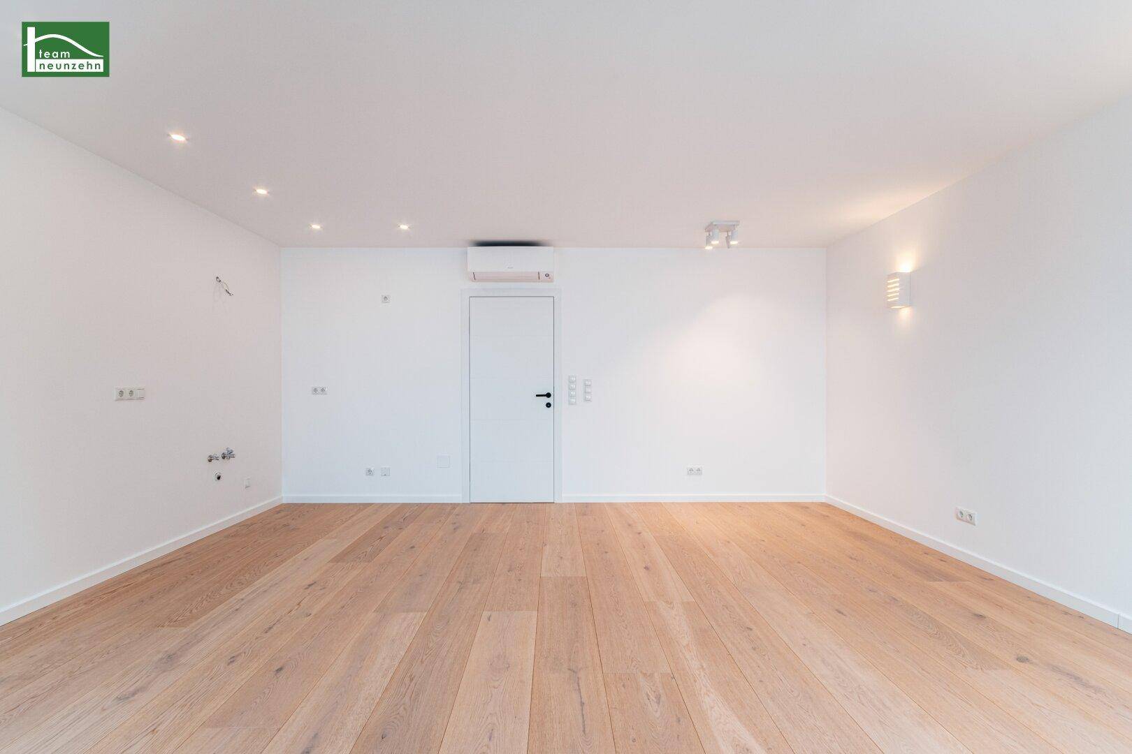 Heller Wohnbereich im Dachgeschoss mit Holzboden, Klimaanlage und moderner Beleuchtung.