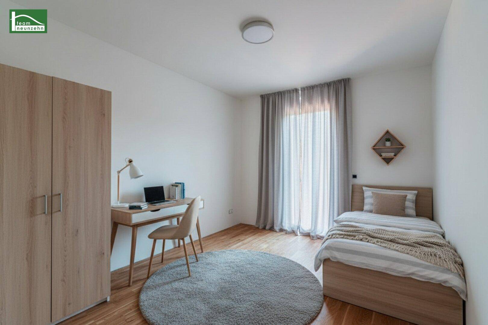 Funktionales Schlafzimmer mit Einzelbett, Schreibtisch, Kleiderschrank und Holzboden.