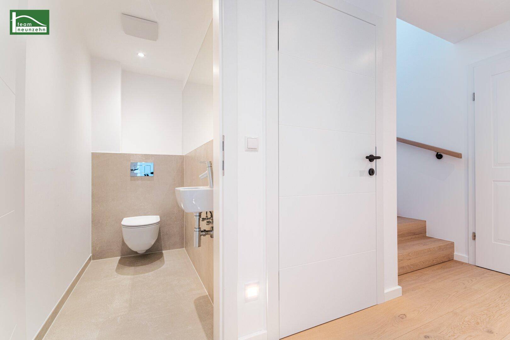 Modernes Gäste-WC mit wandhängender Toilette und kleinem Waschbecken.