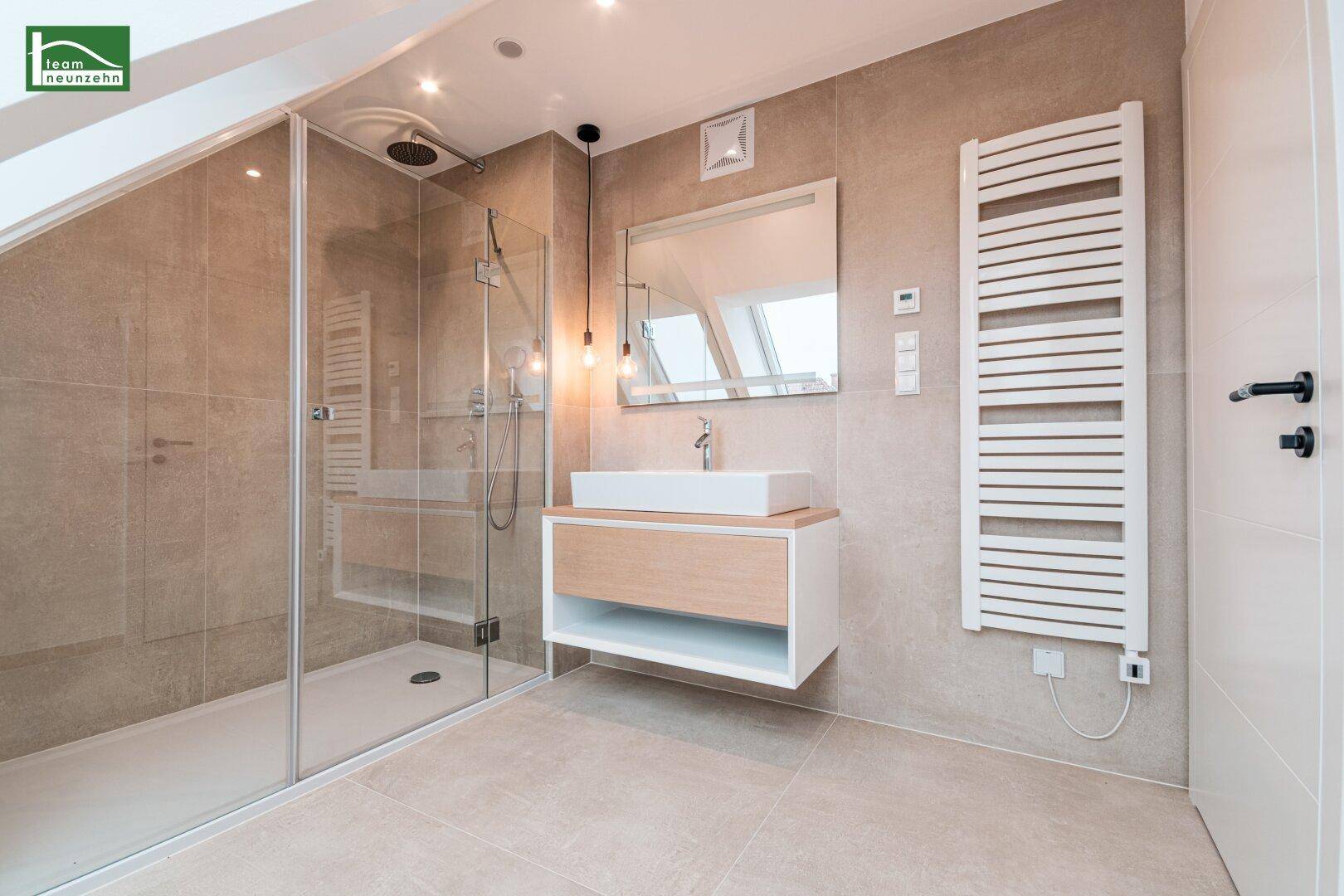 Modernes Badezimmer mit begehbarer Dusche, Waschtisch und beheiztem Handtuchhalter.