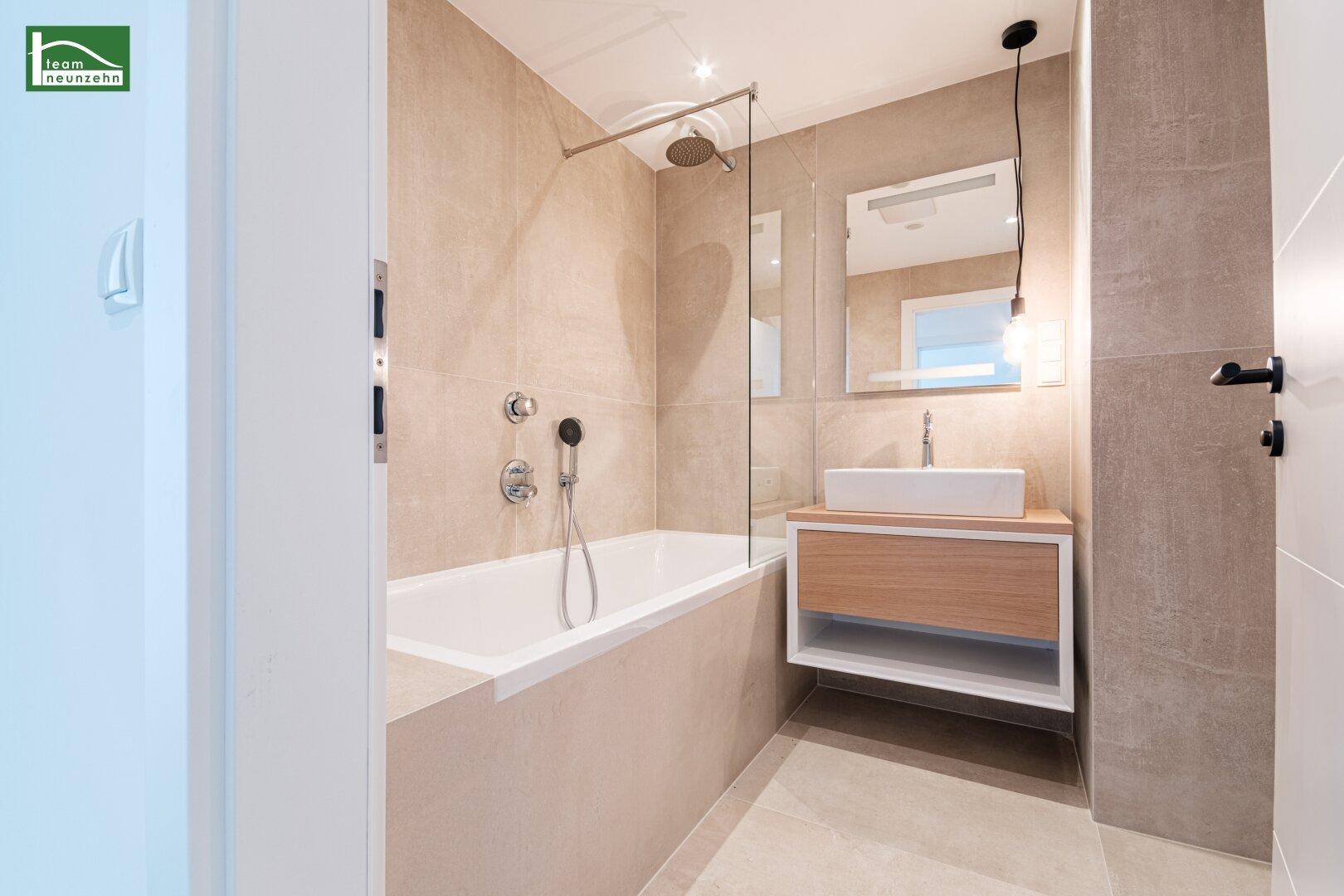 Modernes Badezimmer mit Badewanne, Dusche und stilvollem Waschtisch.