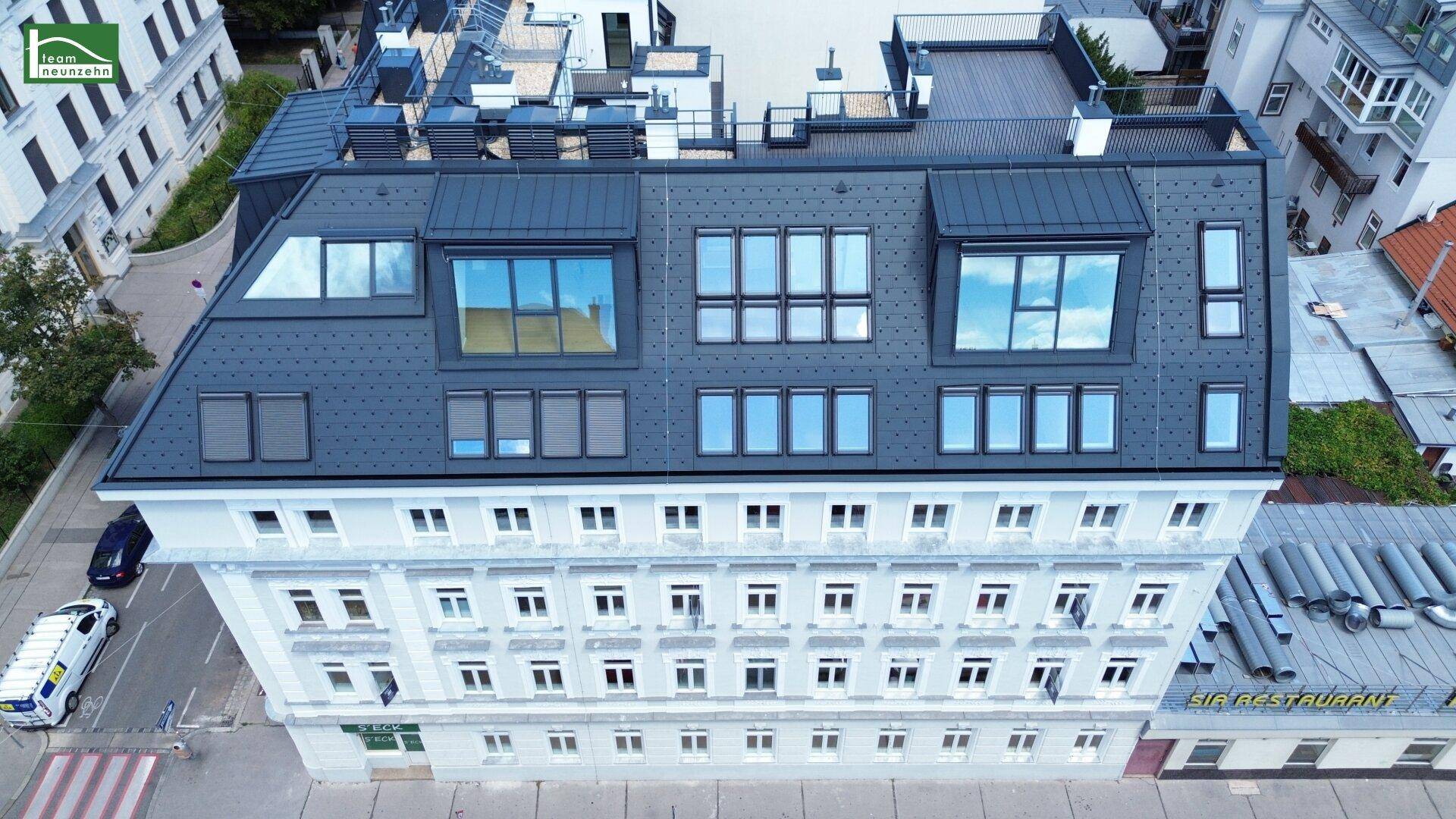 Detailansicht des Gebäudedachs mit zahlreichen Dachfenstern und einer modernen Dachkonstruktion.