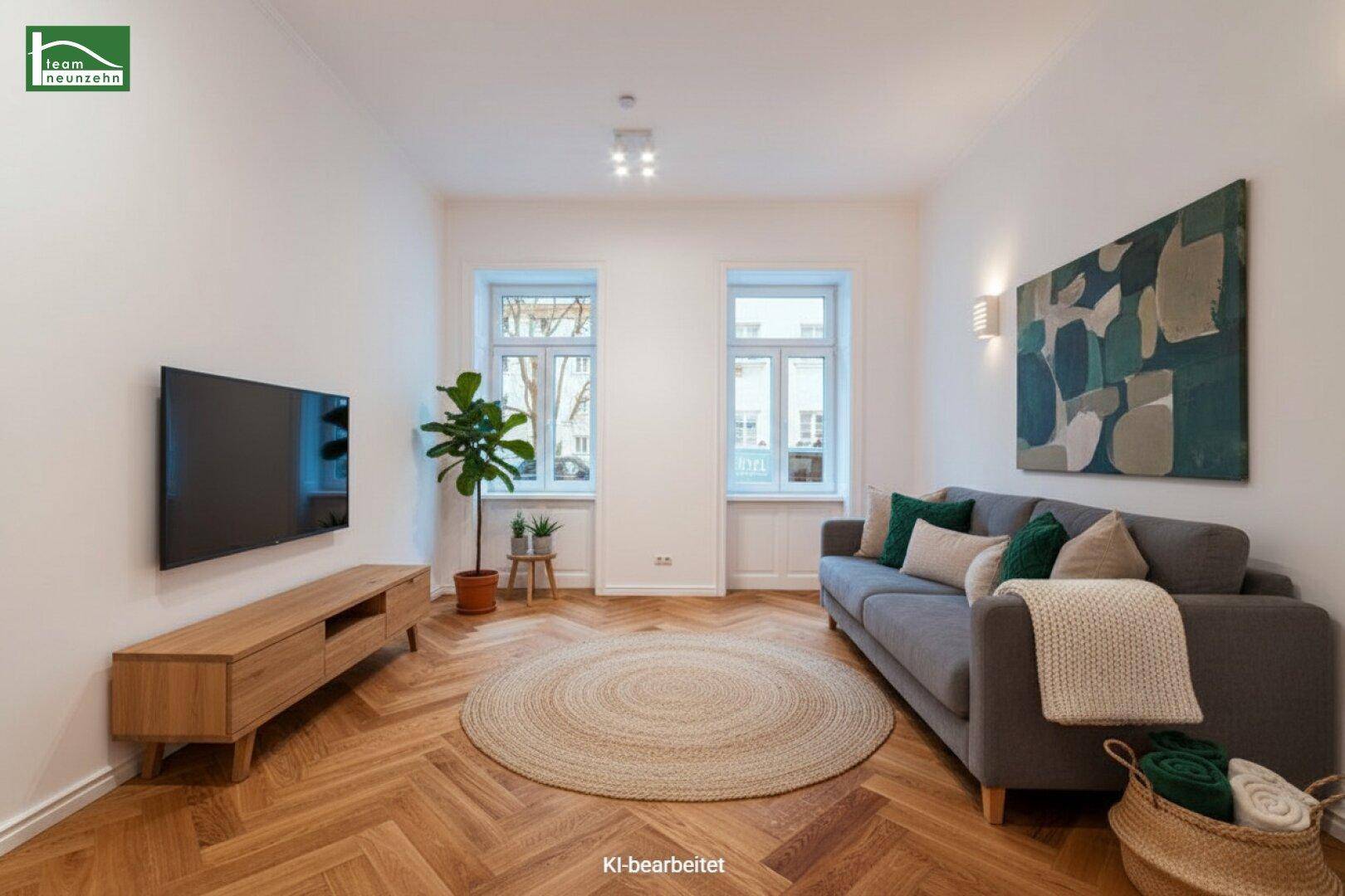Gemütliches Wohnzimmer mit Fischgrätparkett, bequemer Couch und moderner Einrichtung.