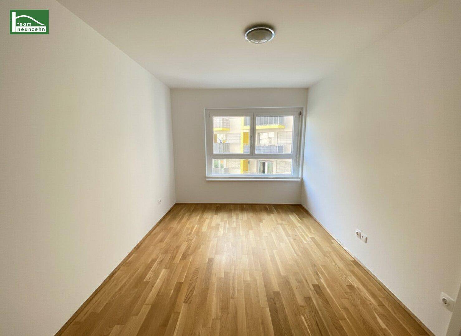 Heller, leerer Raum mit schönem Holzboden und großem Fenster, ideal als Schlafzimmer nutzbar.