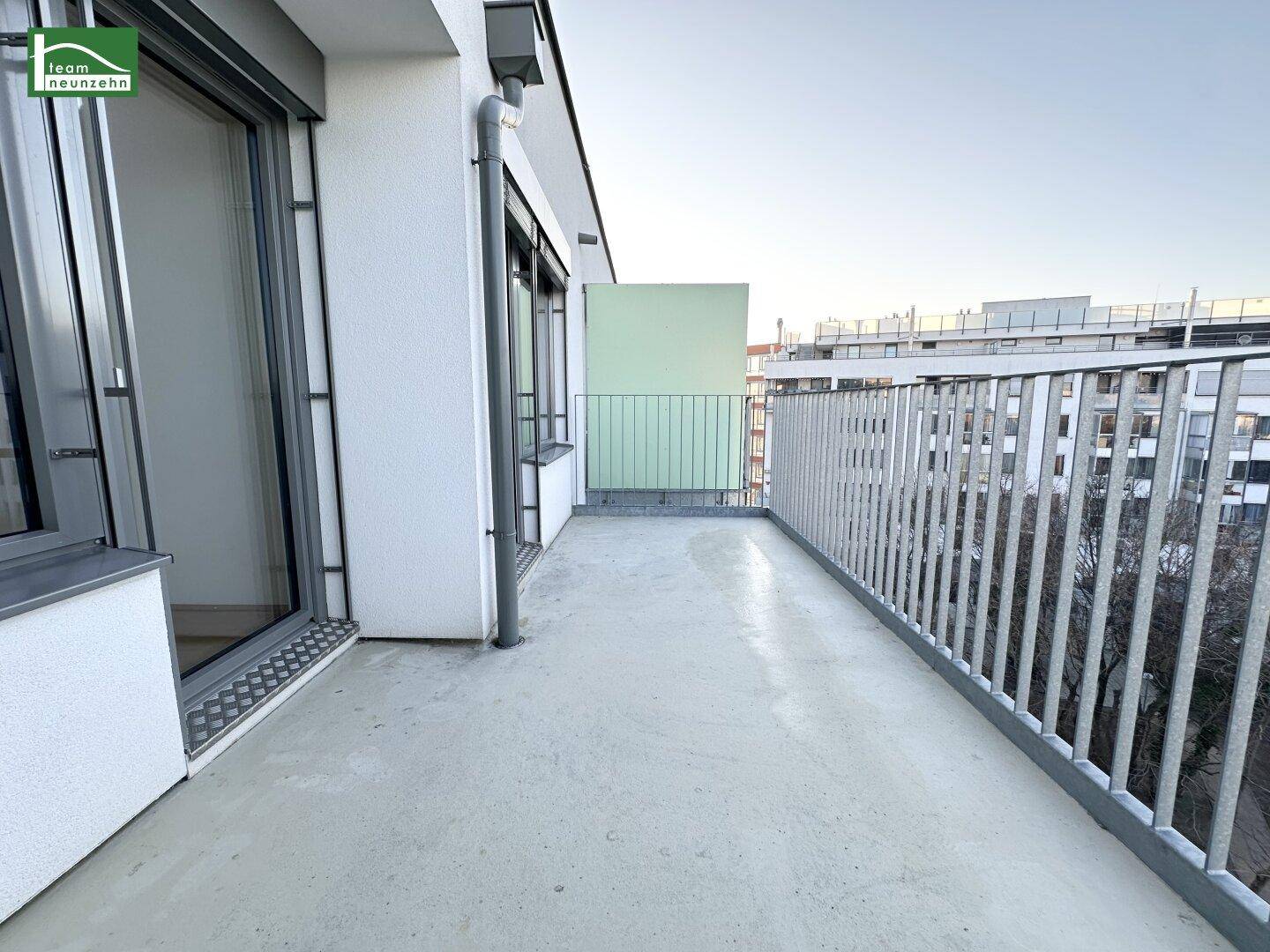 Geräumiger Balkon mit Betonboden und Metallgeländer, bietet Platz im Freien.