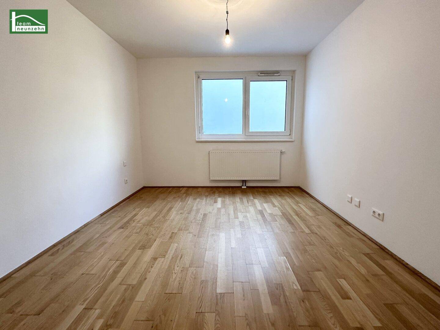Heller Raum mit Holzboden und großem Fenster, vielseitig nutzbar.