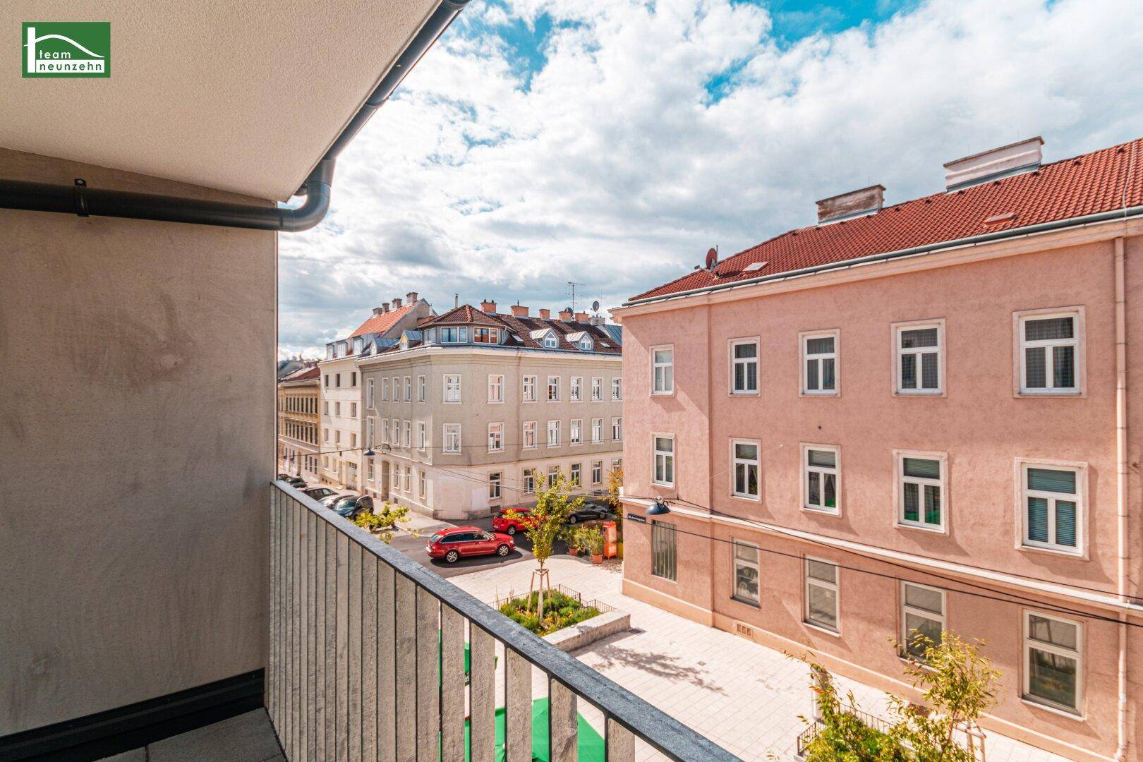 Balkon mit Blick auf eine belebte Straße und historische Gebäude in der Umgebung.