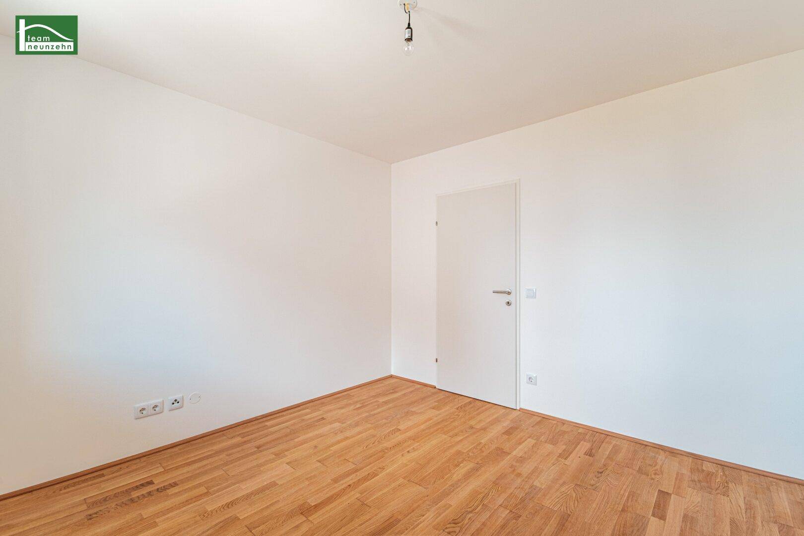 Leerer Raum mit Parkettboden und weiß gestrichenen Wänden, ideal für individuelle Gestaltung.