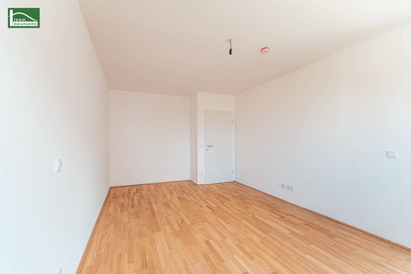 Leerer Raum mit Parkettboden und weiß gestrichenen Wänden, ideal für Schlafzimmer oder Büro.