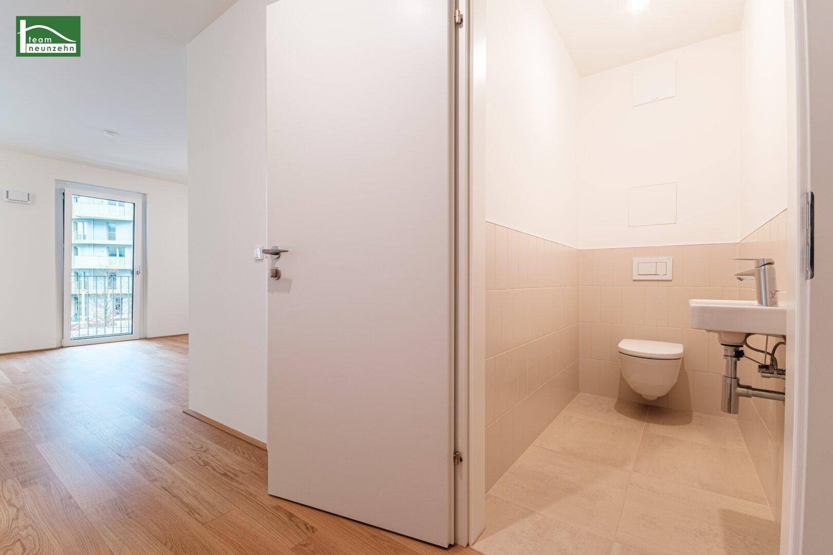 Modernes Gäste-WC mit wandhängender Toilette und kleinem Waschbecken.