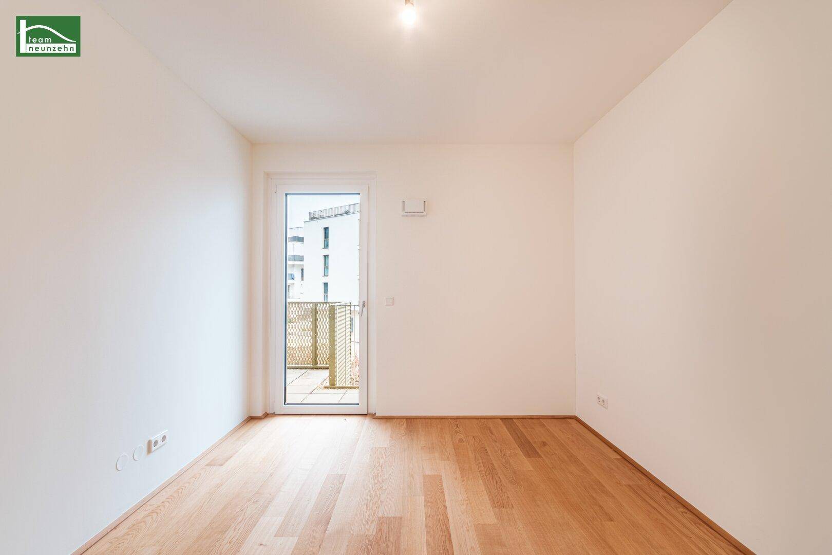 Heller, leerer Raum mit Holzboden und Zugang zu einem kleinen Balkon, ideal für individuelle Gestaltung.
