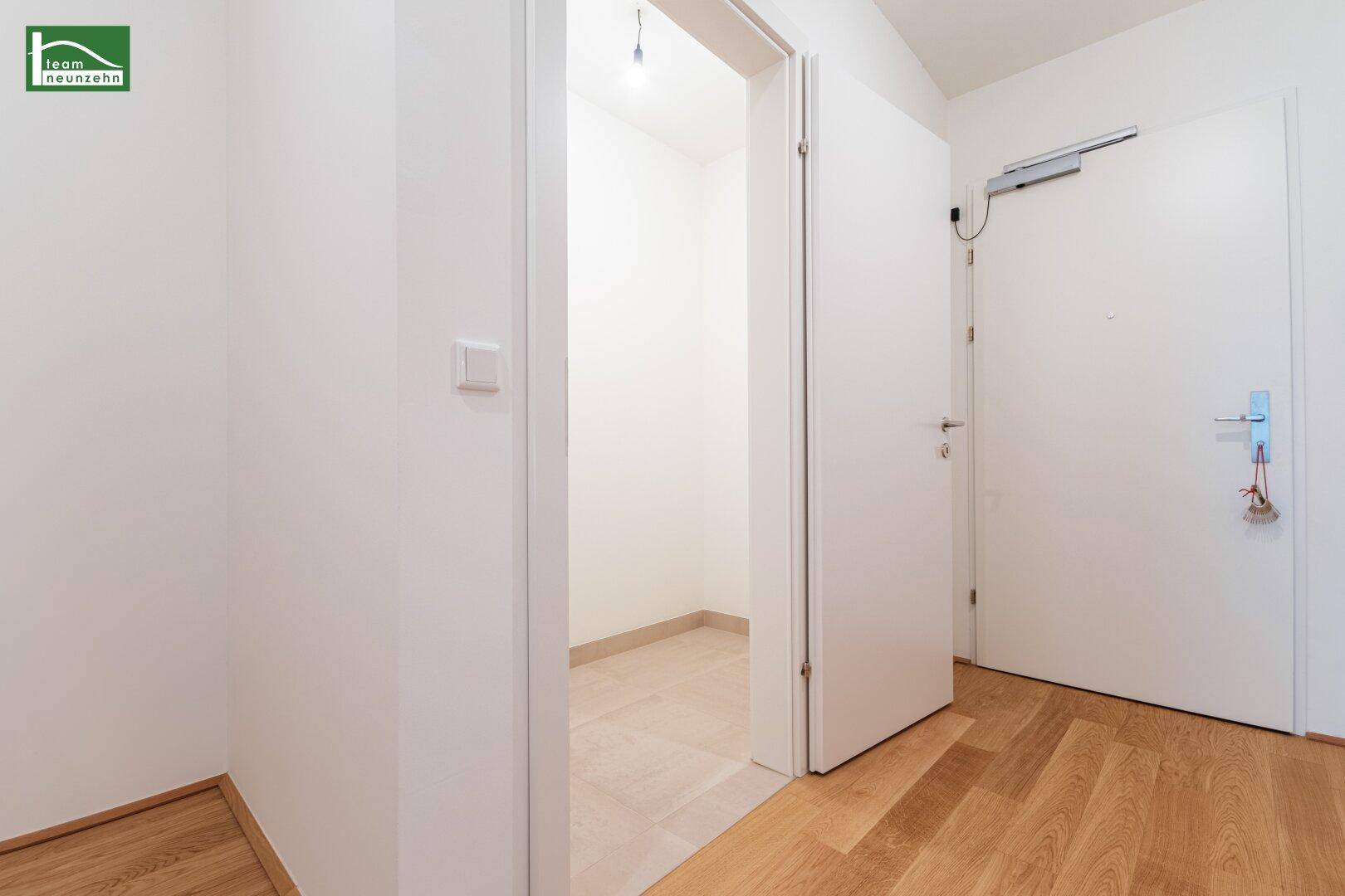 Heller Flur mit Holzboden und Zugang zu einem praktischen Abstellraum.