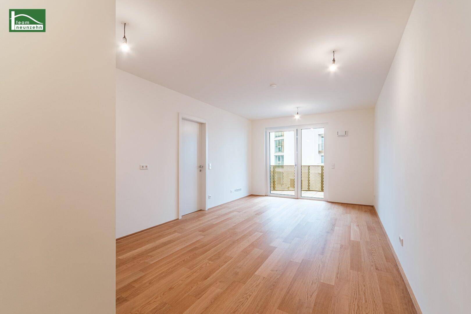 Helles, leeres Zimmer mit Parkettboden und Zugang zu einem Balkon, bereit zur individuellen Gestaltung.