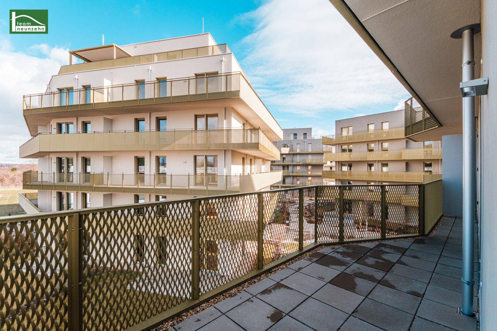Geräumiger Balkon mit Blick auf die modernen Wohngebäude der Anlage und die Umgebung.