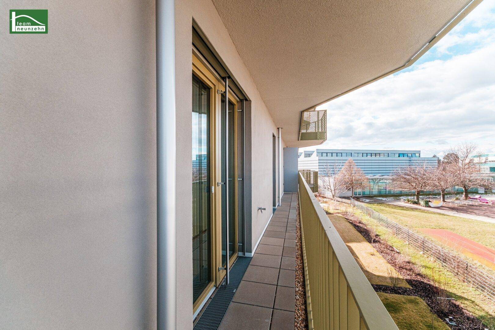 Langer Balkon mit Blick auf die Umgebung und angrenzende Gebäude.