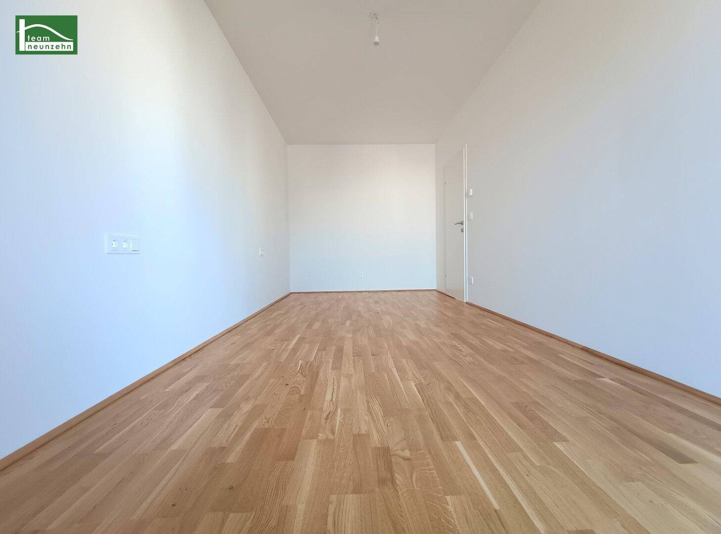 Helles Zimmer mit Parkettboden und weiß gestrichenen Wänden, ideal für Schlaf- oder Arbeitszimmer.