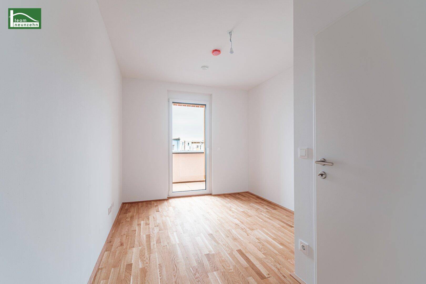 Helles Schlafzimmer mit Parkettboden und direktem Zugang zum Außenbereich, bietet viel Komfort.