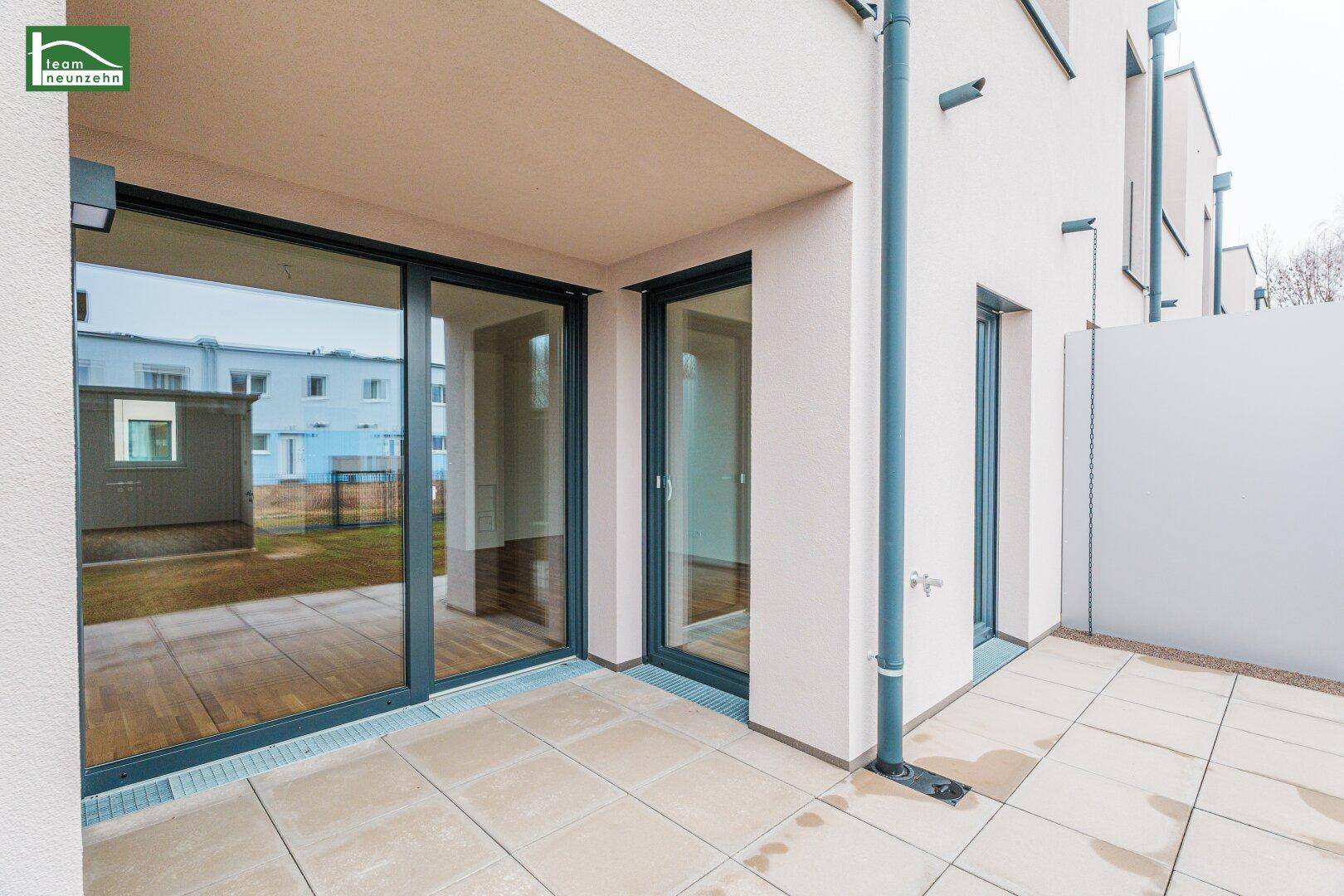 Geräumige Terrasse mit Fliesenboden und Zugang zum Gartenbereich, ideal für Outdoor-Aktivitäten.