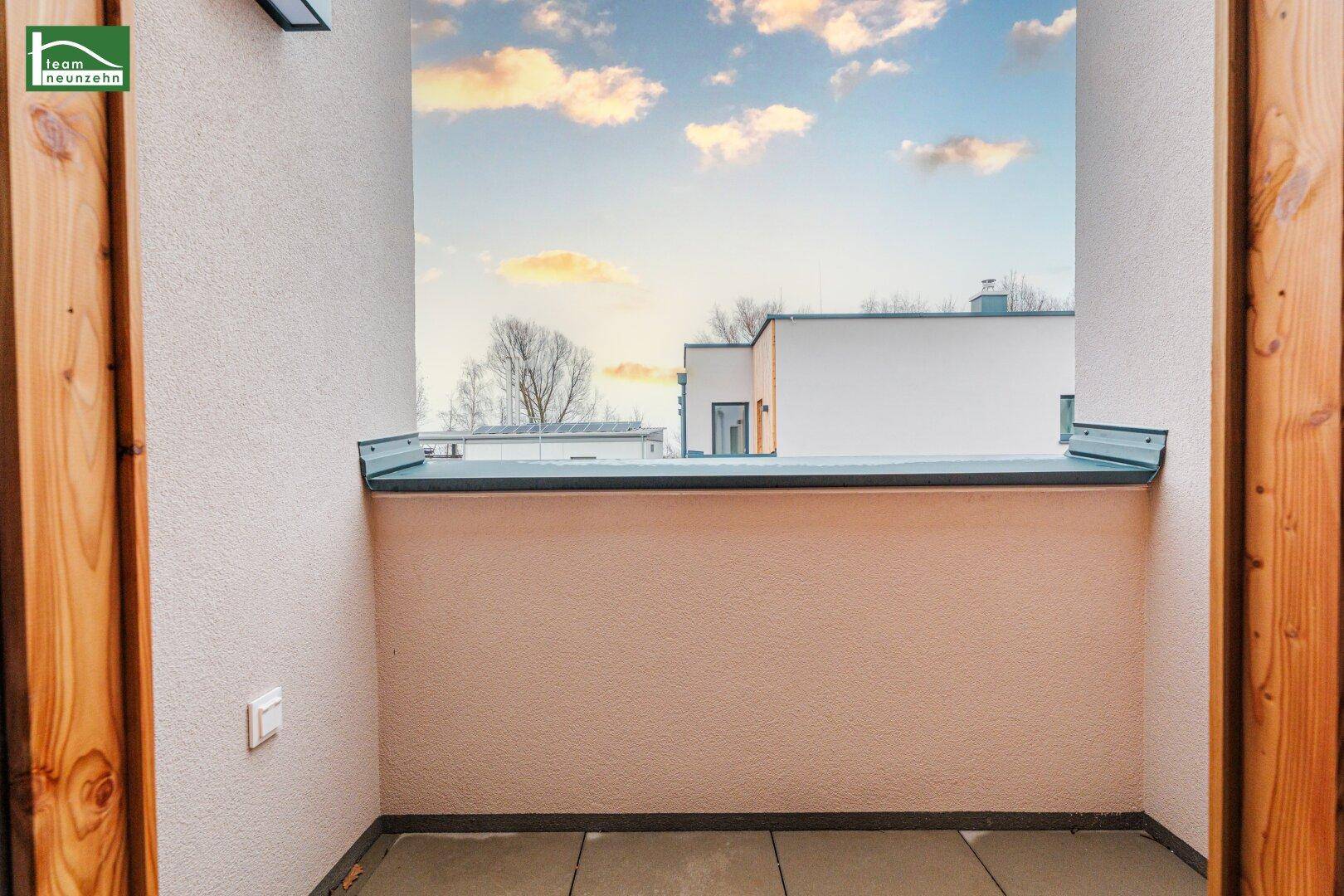 Kleiner, überdachter Balkon mit Fliesenboden und Blick auf die Umgebung, ideal zum Entspannen.