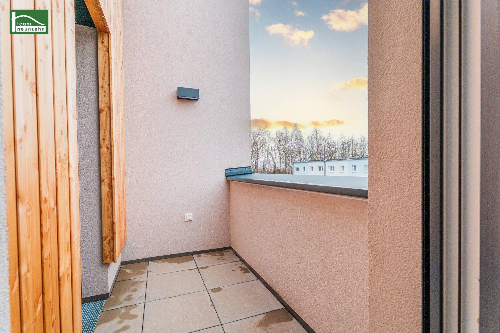 Überdachter Balkon mit Fliesenboden und seitlichem Blick auf die Nachbarschaft, bietet Privatsphäre.
