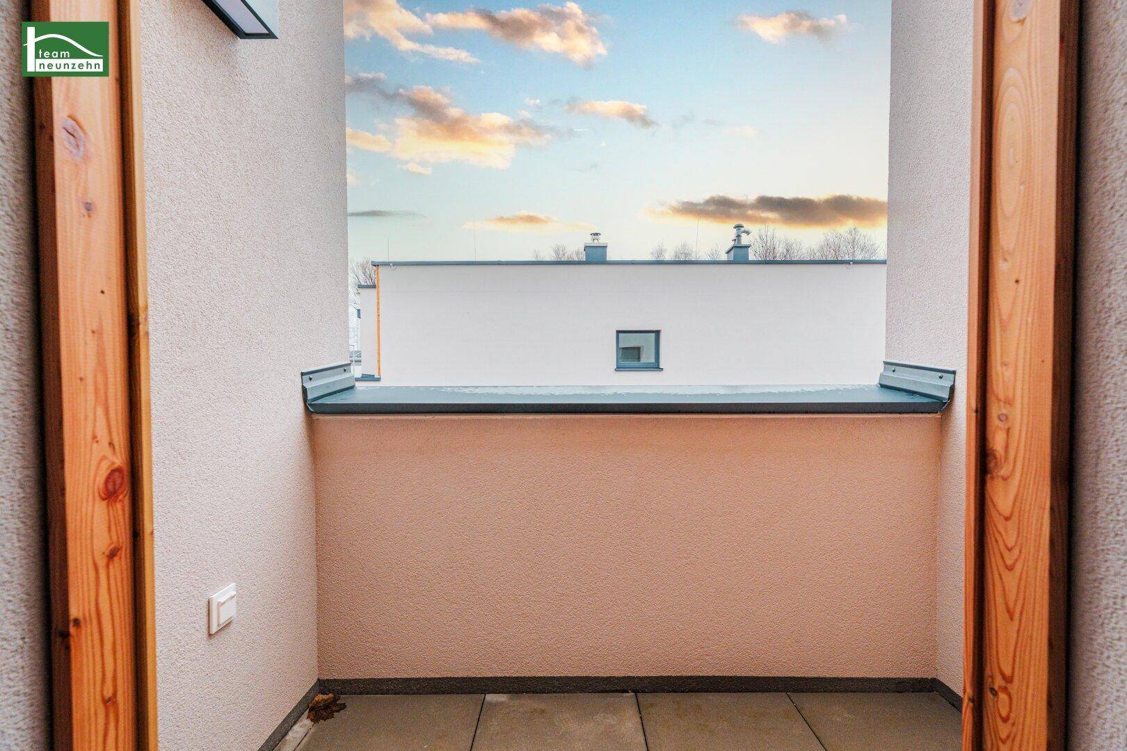 Blick vom Balkon auf die umliegenden Gebäude und den Himmel.