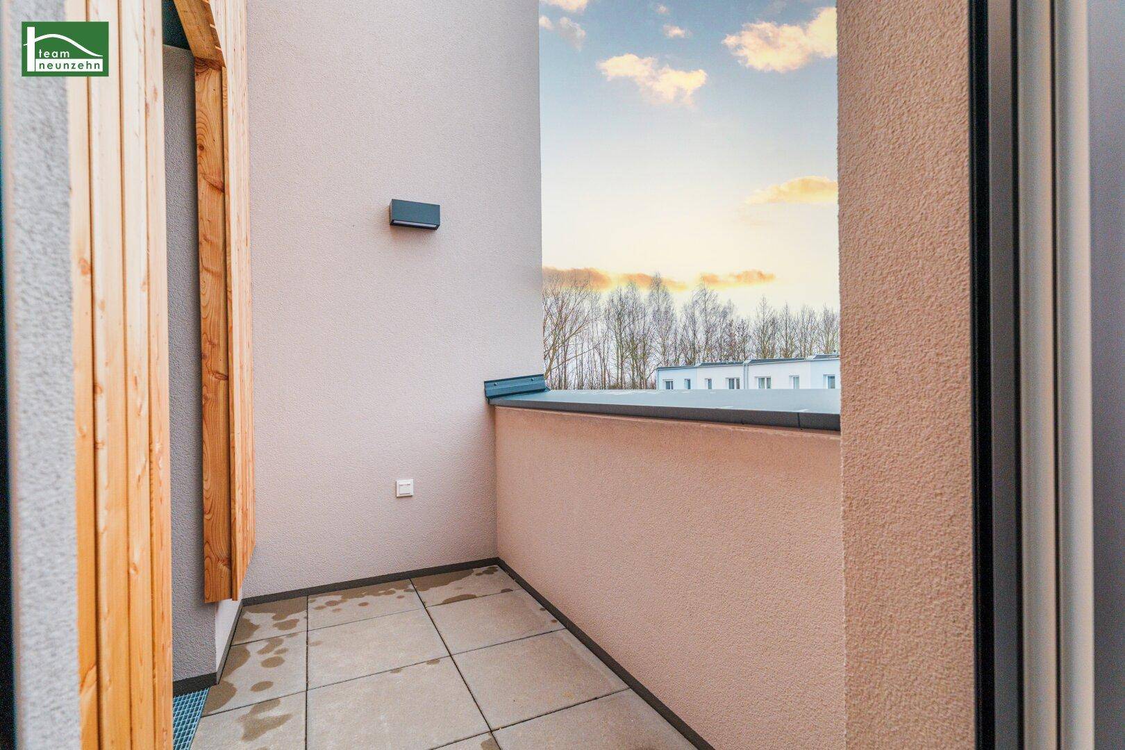 Kleiner, gefliester Balkon mit Blick auf die Umgebung und Holzakzenten.