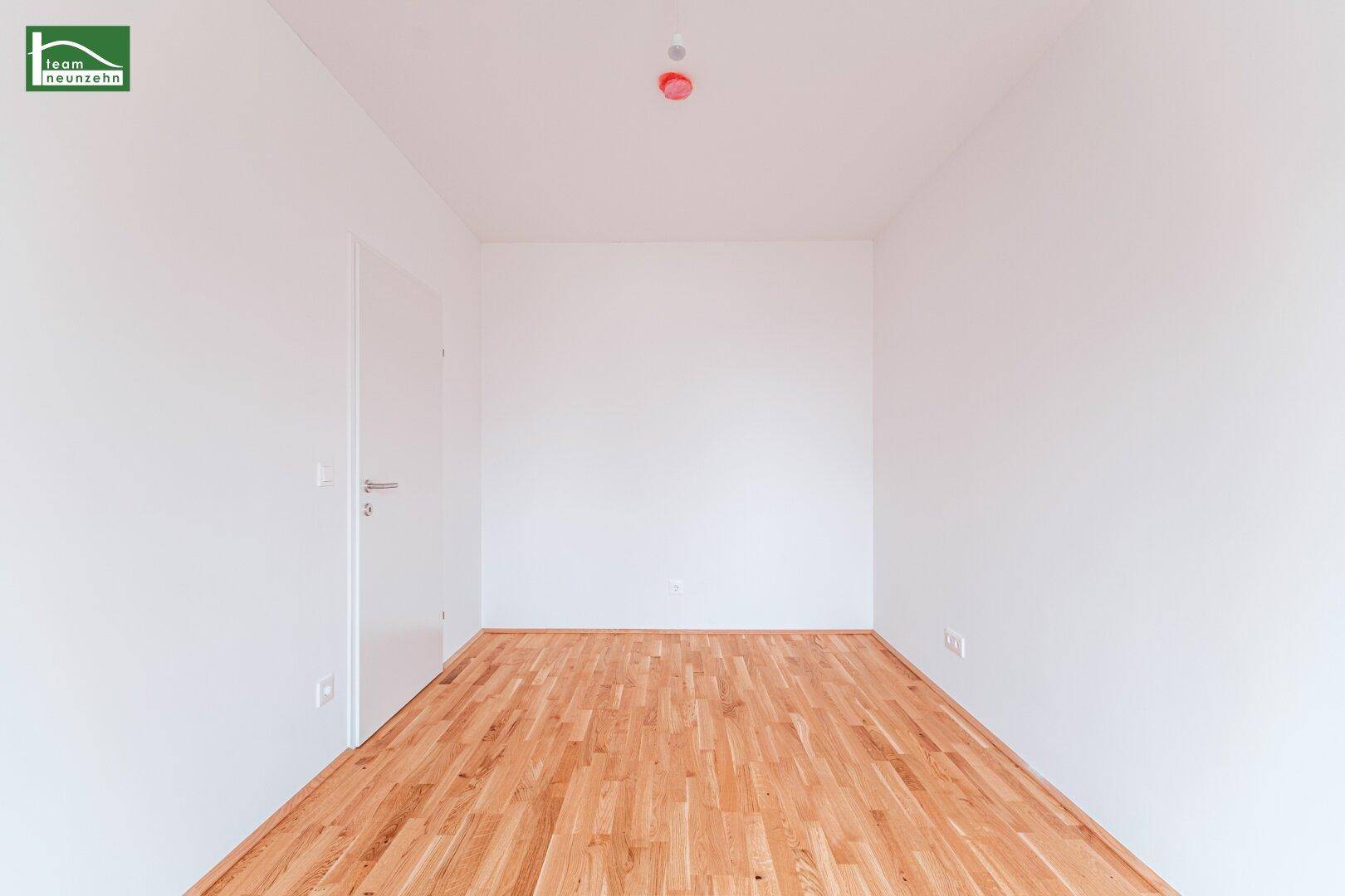 Helles Zimmer mit Parkettboden und weiß gestrichenen Wänden, ideal für Schlaf- oder Kinderzimmer.