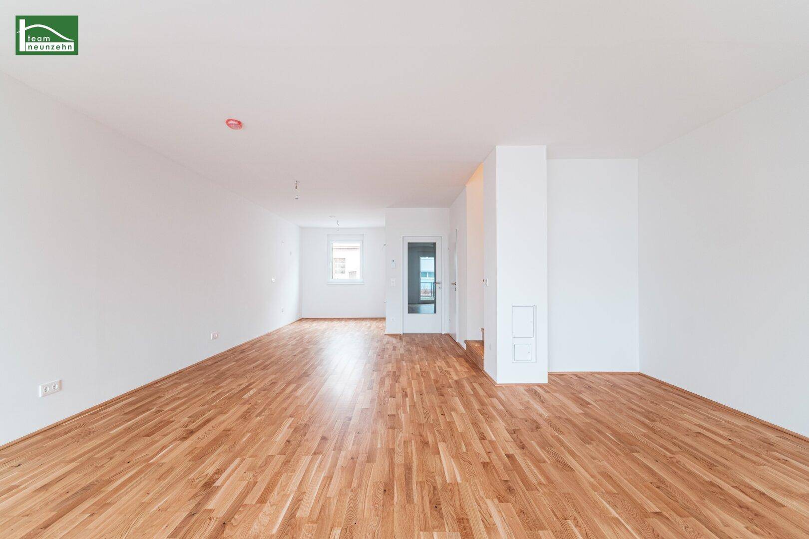 Heller Wohnbereich mit Holzboden und viel Tageslicht, bereit für individuelle Gestaltung.