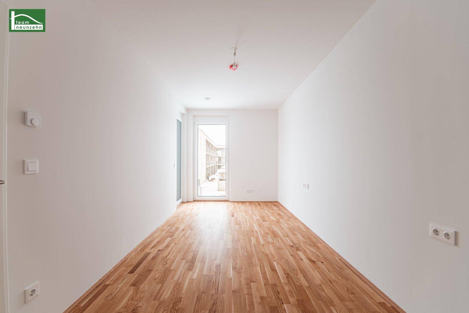 Heller Raum mit Parkettboden und Zugang zu einem Außenbereich, ideal als Schlaf- oder Arbeitszimmer.