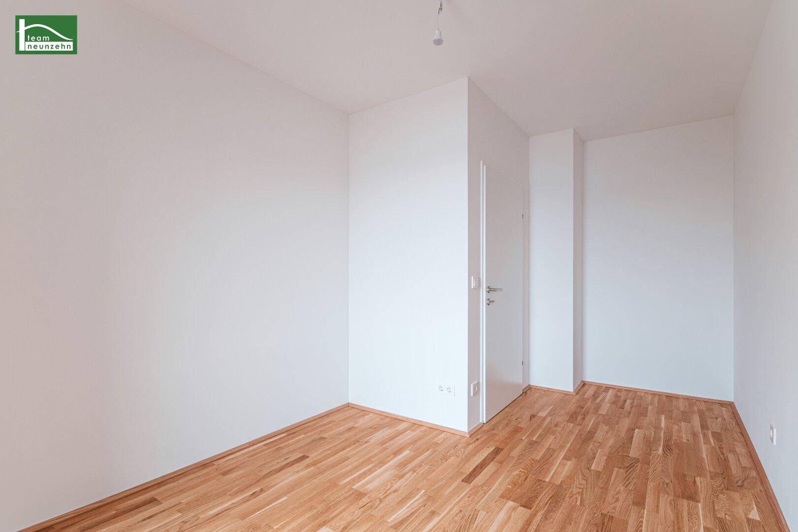 Geräumiges Zimmer mit Parkettboden und weiß gestrichenen Wänden, vielseitig nutzbar.