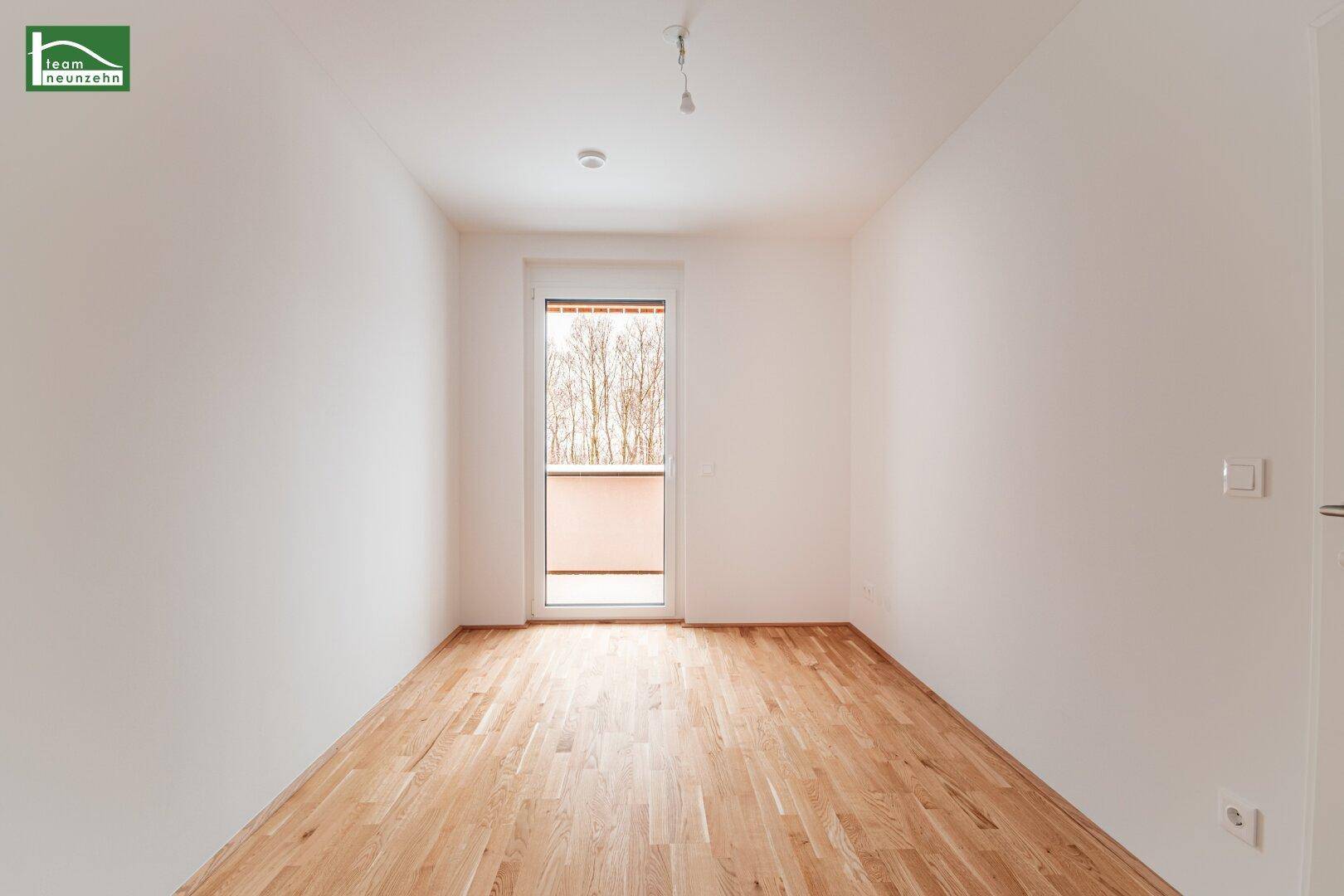 Lichtdurchflutetes Zimmer mit Parkettboden und Balkonzugang, ideal als Schlaf- oder Kinderzimmer.