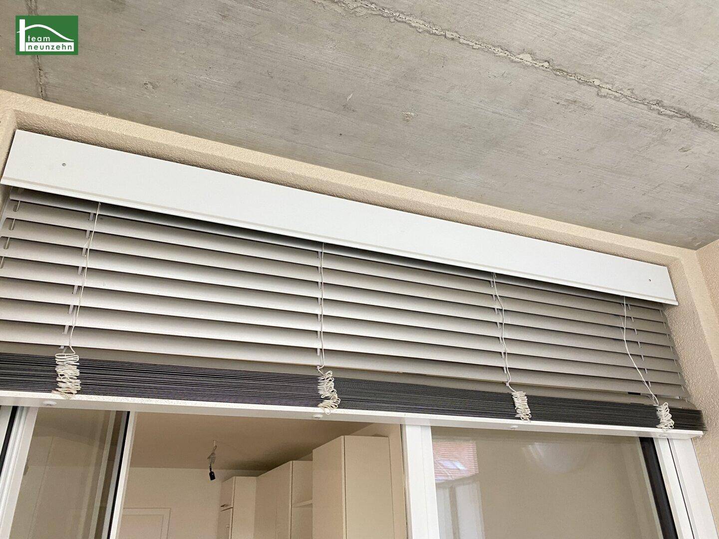 Geschlossene Jalousien vor einem Fenster, die Privatsphäre und Sonnenschutz bieten.