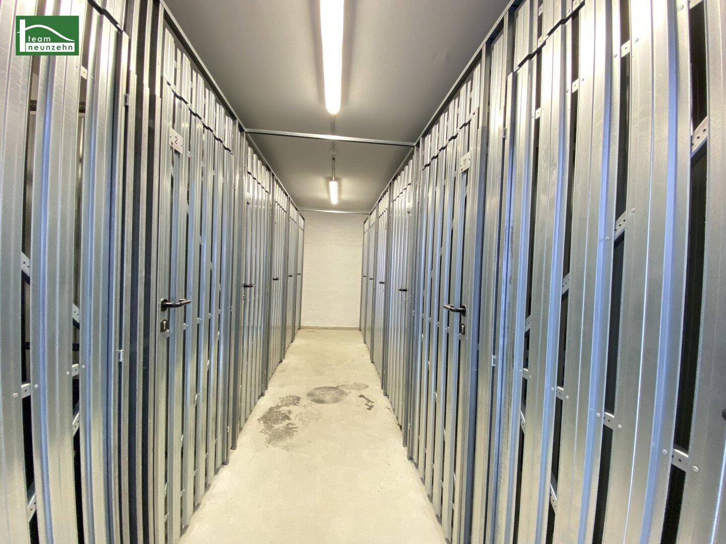 Lange Reihe von abschließbaren Lagerabteilen im Keller, ideal für zusätzlichen Stauraum.