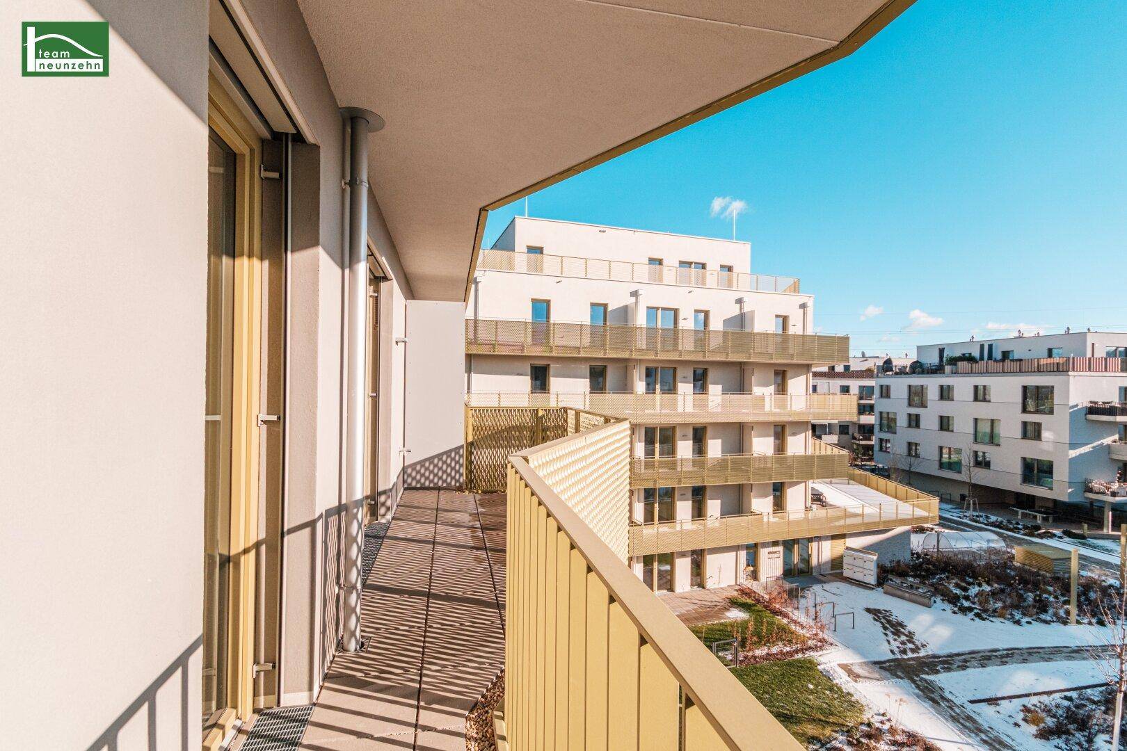 Geräumiger Balkon mit Blick auf die umliegenden Neubauten und Grünflächen.