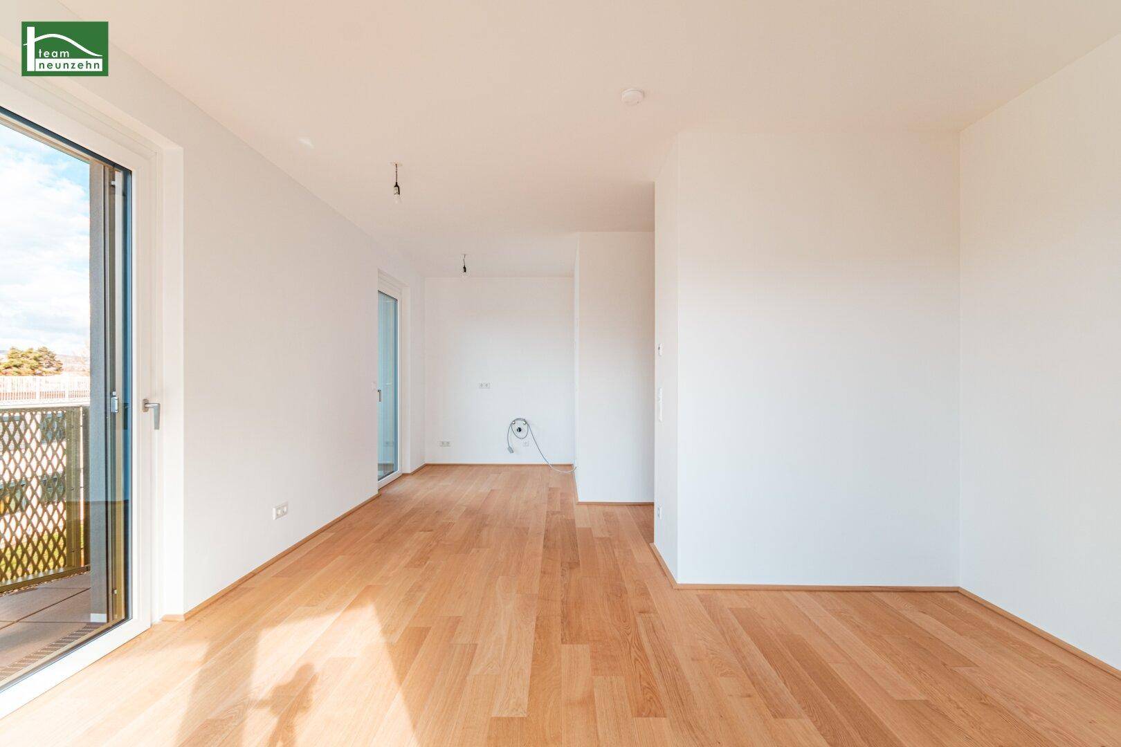 Leerer Raum mit Holzboden und Zugang zu einem Balkon, ideal für individuelle Gestaltung.