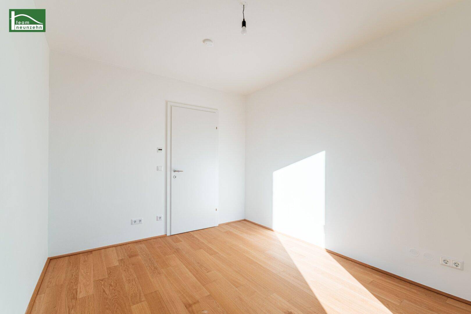 Unmöbliertes Zimmer mit Parkettboden und weiß gestrichenen Wänden, ideal als Schlafzimmer.