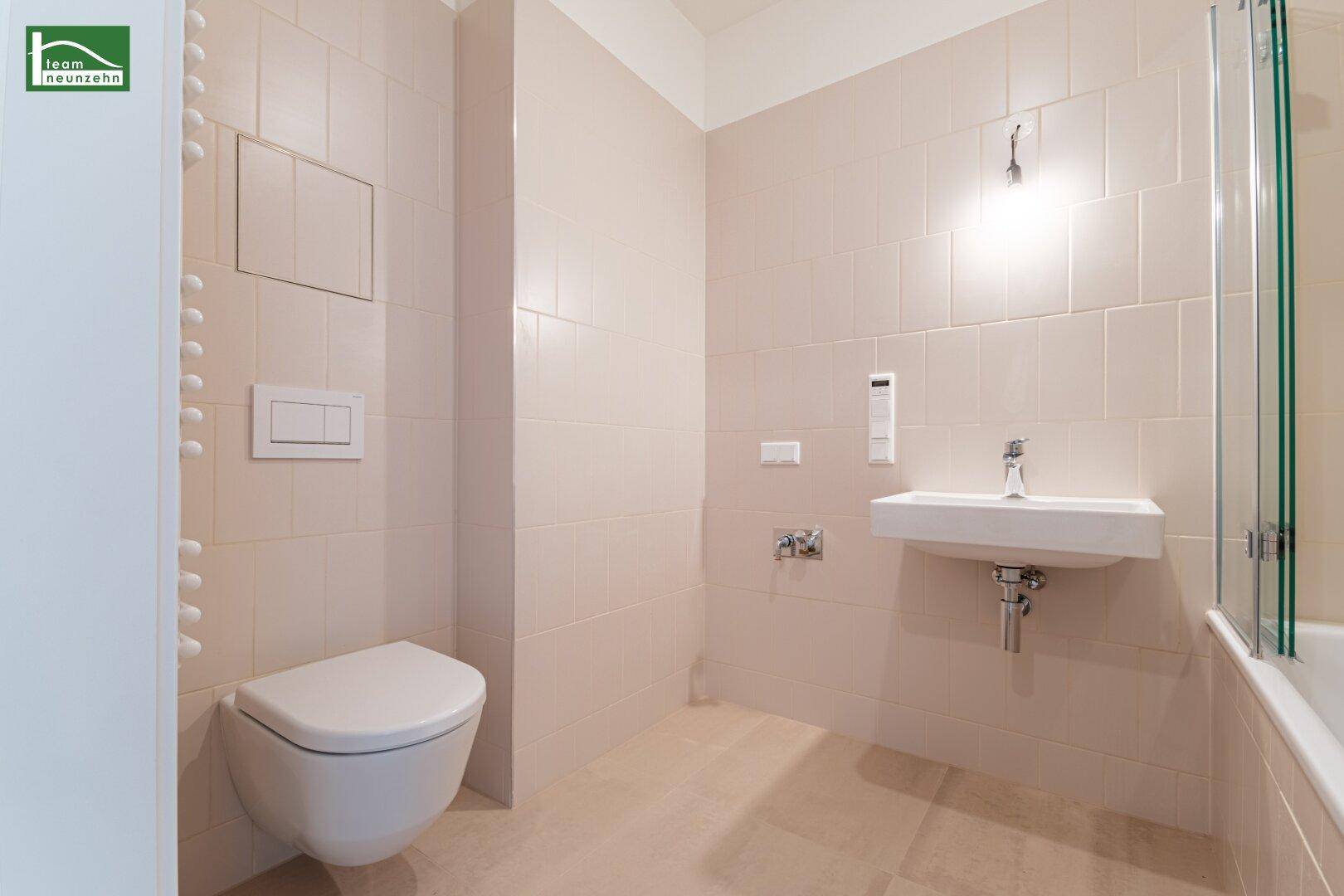Helles Badezimmer mit WC, Waschbecken und Badewanne.